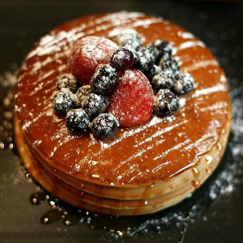 Một đĩa pancake cổ điển được phủ đầy trái cây tươi tại Cafe True Us.